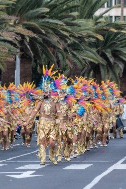 SANTA CRUZ DE TENERIFE, SPAIN - FEBRUARY 21, 2023: Around the Coso parade - along the Avenida de Anaga, official end of Carnival. Amazing warm evening, joyful people in carnival costumes have fun.