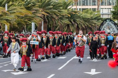 SANTA CRUZ DE TENERIFE, SPAIN - FEBRUARY 21, 2023: Around the Coso parade - along the Avenida de Anaga, official end of Carnival. Amazing warm evening, joyful people in carnival costumes have fun.