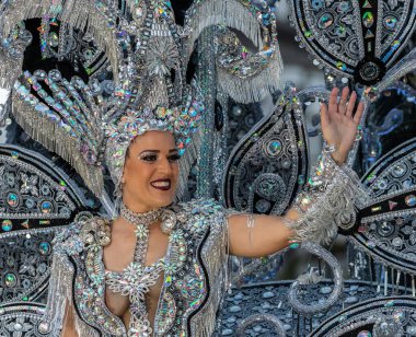 SANTA CRUZ DE TENERIFE, SPAIN - FEBRUARY 21, 2023: Around the Coso parade - along the Avenida de Anaga, official end of Carnival. Amazing warm evening, joyful people in carnival costumes have fun.
