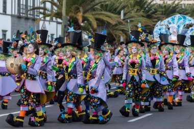 SANTA CRUZ DE TENERIFE, SPAIN - FEBRUARY 21, 2023: Around the Coso parade - along the Avenida de Anaga, official end of Carnival. Amazing warm evening, joyful people in carnival costumes have fun.