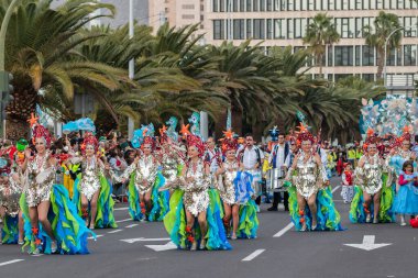 SANTA CRUZ DE TENERIFE, SPAIN - FEBRUARY 21, 2023: Around the Coso parade - along the Avenida de Anaga, official end of Carnival. Amazing warm evening, joyful people in carnival costumes have fun.