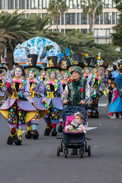 SANTA CRUZ DE TENERIFE, SPAIN - FEBRUARY 21, 2023: Around the Coso parade - along the Avenida de Anaga, official end of Carnival. Amazing warm evening, joyful people in carnival costumes have fun.