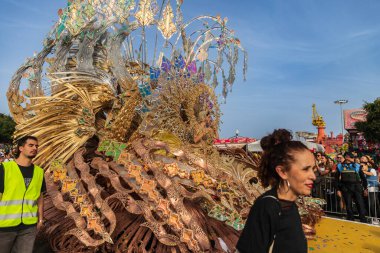 SANTA CRUZ DE TENERIFE, SPAIN - FEBRUARY 13, 2024: The Coso parade, Cavalcada - along the Avenida de Anaga, official end of Carnival. Amazing warm evening, joyful people in carnival costumes have fun. clipart