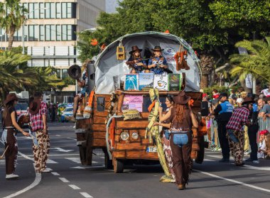 Santa CRUZ DE TENERIFE, İspanya - 13 Şubat 2024: The Coso geçidi, Cavalcada - Avenida de Anaga boyunca, Karnaval 'ın resmi sonu. İnanılmaz sıcak bir akşam, karnaval kostümlü neşeli insanlar eğleniyor..