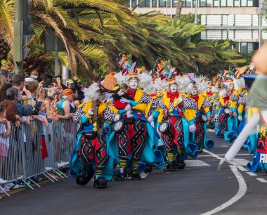 Santa CRUZ DE TENERIFE, İspanya - 13 Şubat 2024: The Coso geçidi, Cavalcada - Avenida de Anaga boyunca, Karnaval 'ın resmi sonu. İnanılmaz sıcak bir akşam, karnaval kostümlü neşeli insanlar eğleniyor..