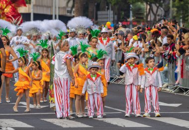 Santa CRUZ DE TENERIFE, İspanya - 13 Şubat 2024: The Coso geçidi, Cavalcada - Avenida de Anaga boyunca, Karnaval 'ın resmi sonu. İnanılmaz sıcak bir akşam, karnaval kostümlü neşeli insanlar eğleniyor..