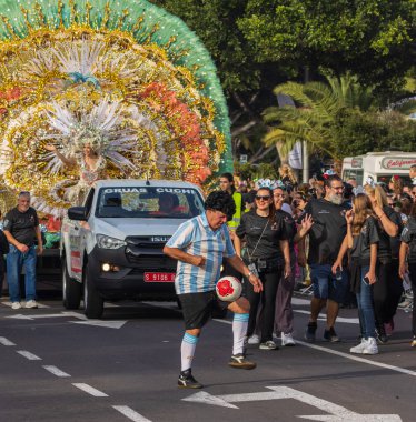 Santa CRUZ DE TENERIFE, İspanya - 13 Şubat 2024: The Coso geçidi, Cavalcada - Avenida de Anaga boyunca, Karnaval 'ın resmi sonu. İnanılmaz sıcak bir akşam, karnaval kostümlü neşeli insanlar eğleniyor..