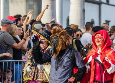 Santa CRUZ DE TENERIFE, İspanya - 13 Şubat 2024: The Coso geçidi, Cavalcada - Avenida de Anaga boyunca, Karnaval 'ın resmi sonu. İnanılmaz sıcak bir akşam, karnaval kostümlü neşeli insanlar eğleniyor..