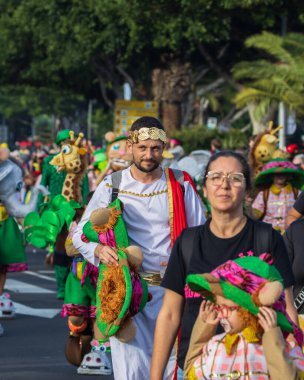 Santa CRUZ DE TENERIFE, İspanya - 13 Şubat 2024: The Coso geçidi, Cavalcada - Avenida de Anaga boyunca, Karnaval 'ın resmi sonu. İnanılmaz sıcak bir akşam, karnaval kostümlü neşeli insanlar eğleniyor..