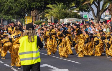 Santa CRUZ DE TENERIFE, İspanya - 13 Şubat 2024: The Coso geçidi, Cavalcada - Avenida de Anaga boyunca, Karnaval 'ın resmi sonu. İnanılmaz sıcak bir akşam, karnaval kostümlü neşeli insanlar eğleniyor..