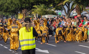 Santa CRUZ DE TENERIFE, İspanya - 13 Şubat 2024: The Coso geçidi, Cavalcada - Avenida de Anaga boyunca, Karnaval 'ın resmi sonu. İnanılmaz sıcak bir akşam, karnaval kostümlü neşeli insanlar eğleniyor..