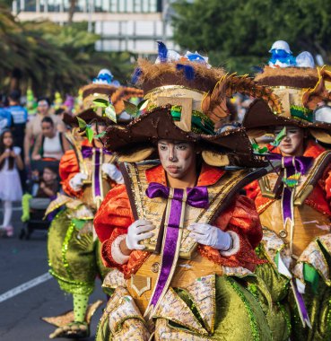 Santa CRUZ DE TENERIFE, İspanya - 13 Şubat 2024: The Coso geçidi, Cavalcada - Avenida de Anaga boyunca, Karnaval 'ın resmi sonu. İnanılmaz sıcak bir akşam, karnaval kostümlü neşeli insanlar eğleniyor..