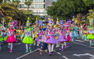 Santa CRUZ DE TENERIFE, İspanya - 13 Şubat 2024: The Coso geçidi, Cavalcada - Avenida de Anaga boyunca, Karnaval 'ın resmi sonu. İnanılmaz sıcak bir akşam, karnaval kostümlü neşeli insanlar eğleniyor..