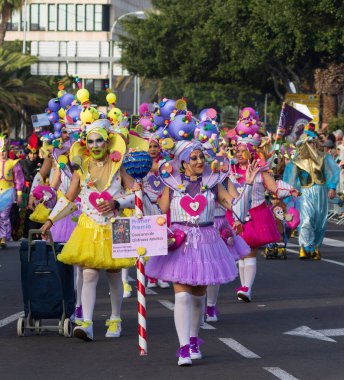 Santa CRUZ DE TENERIFE, İspanya - 13 Şubat 2024: The Coso geçidi, Cavalcada - Avenida de Anaga boyunca, Karnaval 'ın resmi sonu. İnanılmaz sıcak bir akşam, karnaval kostümlü neşeli insanlar eğleniyor..