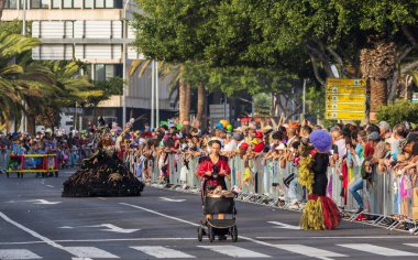 Santa CRUZ DE TENERIFE, İspanya - 13 Şubat 2024: The Coso geçidi, Cavalcada - Avenida de Anaga boyunca, Karnaval 'ın resmi sonu. İnanılmaz sıcak bir akşam, karnaval kostümlü neşeli insanlar eğleniyor..