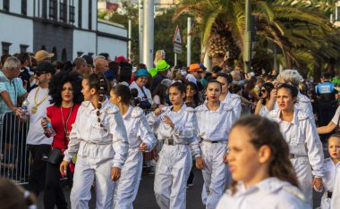 Santa CRUZ DE TENERIFE, İspanya - 13 Şubat 2024: The Coso geçidi, Cavalcada - Avenida de Anaga boyunca, Karnaval 'ın resmi sonu. İnanılmaz sıcak bir akşam, karnaval kostümlü neşeli insanlar eğleniyor..