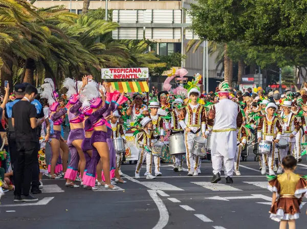 Santa CRUZ DE TENERIFE, İspanya - 13 Şubat 2024: The Coso geçidi, Cavalcada - Avenida de Anaga boyunca, Karnaval 'ın resmi sonu. İnanılmaz sıcak bir akşam, karnaval kostümlü neşeli insanlar eğleniyor..