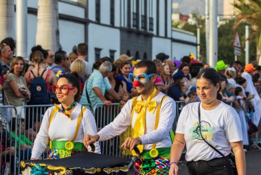 Santa CRUZ DE TENERIFE, İspanya - 13 Şubat 2024: The Coso geçidi, Cavalcada - Avenida de Anaga boyunca, Karnaval 'ın resmi sonu. İnanılmaz sıcak bir akşam, karnaval kostümlü neşeli insanlar eğleniyor..