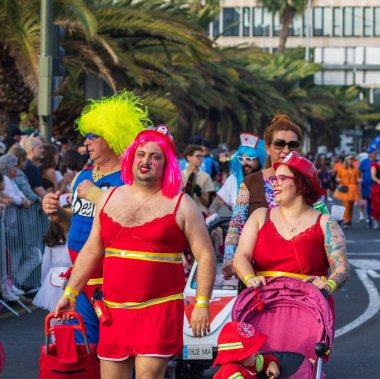 Santa CRUZ DE TENERIFE, İspanya - 13 Şubat 2024: The Coso geçidi, Cavalcada - Avenida de Anaga boyunca, Karnaval 'ın resmi sonu. İnanılmaz sıcak bir akşam, karnaval kostümlü neşeli insanlar eğleniyor..