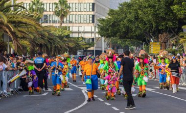 Santa CRUZ DE TENERIFE, İspanya - 13 Şubat 2024: The Coso geçidi, Cavalcada - Avenida de Anaga boyunca, Karnaval 'ın resmi sonu. İnanılmaz sıcak bir akşam, karnaval kostümlü neşeli insanlar eğleniyor..