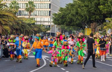 Santa CRUZ DE TENERIFE, İspanya - 13 Şubat 2024: The Coso geçidi, Cavalcada - Avenida de Anaga boyunca, Karnaval 'ın resmi sonu. İnanılmaz sıcak bir akşam, karnaval kostümlü neşeli insanlar eğleniyor..