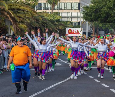 Santa CRUZ DE TENERIFE, İspanya - 13 Şubat 2024: The Coso geçidi, Cavalcada - Avenida de Anaga boyunca, Karnaval 'ın resmi sonu. İnanılmaz sıcak bir akşam, karnaval kostümlü neşeli insanlar eğleniyor..