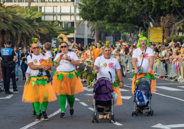 Santa CRUZ DE TENERIFE, İspanya - 13 Şubat 2024: The Coso geçidi, Cavalcada - Avenida de Anaga boyunca, Karnaval 'ın resmi sonu. İnanılmaz sıcak bir akşam, karnaval kostümlü neşeli insanlar eğleniyor..