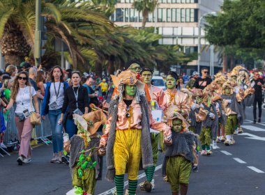 Santa CRUZ DE TENERIFE, İspanya - 13 Şubat 2024: The Coso geçidi, Cavalcada - Avenida de Anaga boyunca, Karnaval 'ın resmi sonu. İnanılmaz sıcak bir akşam, karnaval kostümlü neşeli insanlar eğleniyor..