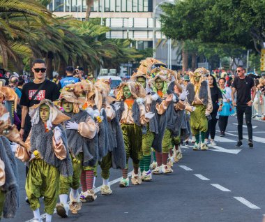 Santa CRUZ DE TENERIFE, İspanya - 13 Şubat 2024: The Coso geçidi, Cavalcada - Avenida de Anaga boyunca, Karnaval 'ın resmi sonu. İnanılmaz sıcak bir akşam, karnaval kostümlü neşeli insanlar eğleniyor..