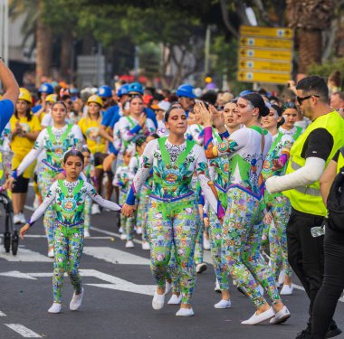 Santa CRUZ DE TENERIFE, İspanya - 13 Şubat 2024: The Coso geçidi, Cavalcada - Avenida de Anaga boyunca, Karnaval 'ın resmi sonu. İnanılmaz sıcak bir akşam, karnaval kostümlü neşeli insanlar eğleniyor..