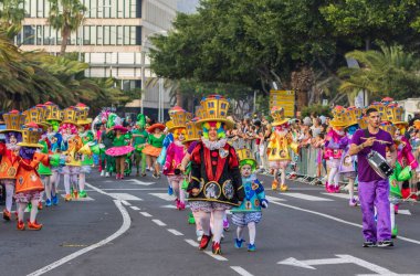Santa CRUZ DE TENERIFE, İspanya - 13 Şubat 2024: The Coso geçidi, Cavalcada - Avenida de Anaga boyunca, Karnaval 'ın resmi sonu. İnanılmaz sıcak bir akşam, karnaval kostümlü neşeli insanlar eğleniyor..