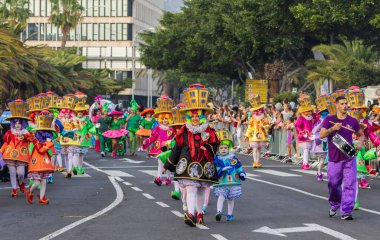 Santa CRUZ DE TENERIFE, İspanya - 13 Şubat 2024: The Coso geçidi, Cavalcada - Avenida de Anaga boyunca, Karnaval 'ın resmi sonu. İnanılmaz sıcak bir akşam, karnaval kostümlü neşeli insanlar eğleniyor..