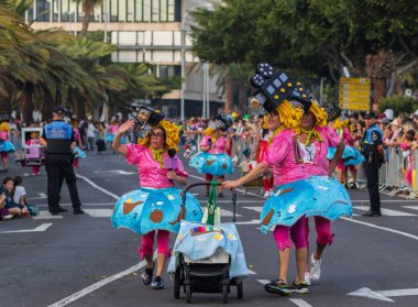Santa CRUZ DE TENERIFE, İspanya - 13 Şubat 2024: The Coso geçidi, Cavalcada - Avenida de Anaga boyunca, Karnaval 'ın resmi sonu. İnanılmaz sıcak bir akşam, karnaval kostümlü neşeli insanlar eğleniyor..