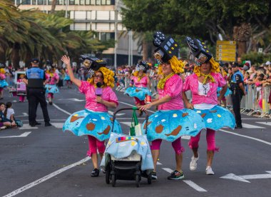 Santa CRUZ DE TENERIFE, İspanya - 13 Şubat 2024: The Coso geçidi, Cavalcada - Avenida de Anaga boyunca, Karnaval 'ın resmi sonu. İnanılmaz sıcak bir akşam, karnaval kostümlü neşeli insanlar eğleniyor..