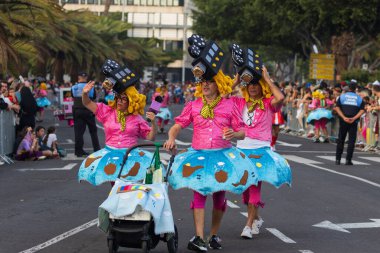 Santa CRUZ DE TENERIFE, İspanya - 13 Şubat 2024: The Coso geçidi, Cavalcada - Avenida de Anaga boyunca, Karnaval 'ın resmi sonu. İnanılmaz sıcak bir akşam, karnaval kostümlü neşeli insanlar eğleniyor..