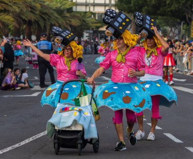 Santa CRUZ DE TENERIFE, İspanya - 13 Şubat 2024: The Coso geçidi, Cavalcada - Avenida de Anaga boyunca, Karnaval 'ın resmi sonu. İnanılmaz sıcak bir akşam, karnaval kostümlü neşeli insanlar eğleniyor..