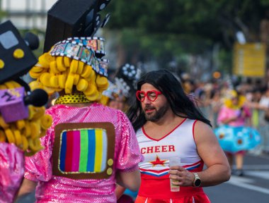 Santa CRUZ DE TENERIFE, İspanya - 13 Şubat 2024: The Coso geçidi, Cavalcada - Avenida de Anaga boyunca, Karnaval 'ın resmi sonu. İnanılmaz sıcak bir akşam, karnaval kostümlü neşeli insanlar eğleniyor..