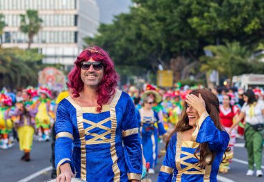 Santa CRUZ DE TENERIFE, İspanya - 13 Şubat 2024: The Coso geçidi, Cavalcada - Avenida de Anaga boyunca, Karnaval 'ın resmi sonu. İnanılmaz sıcak bir akşam, karnaval kostümlü neşeli insanlar eğleniyor..