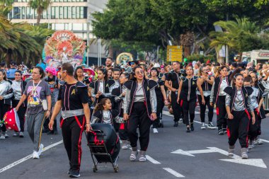 Santa CRUZ DE TENERIFE, İspanya - 13 Şubat 2024: The Coso geçidi, Cavalcada - Avenida de Anaga boyunca, Karnaval 'ın resmi sonu. İnanılmaz sıcak bir akşam, karnaval kostümlü neşeli insanlar eğleniyor..