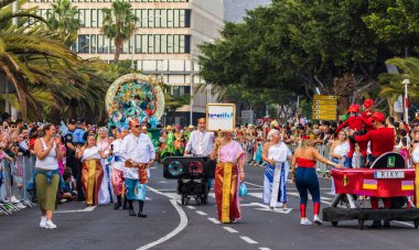 Santa CRUZ DE TENERIFE, İspanya - 13 Şubat 2024: The Coso geçidi, Cavalcada - Avenida de Anaga boyunca, Karnaval 'ın resmi sonu. İnanılmaz sıcak bir akşam, karnaval kostümlü neşeli insanlar eğleniyor..