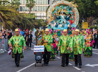 Santa CRUZ DE TENERIFE, İspanya - 13 Şubat 2024: The Coso geçidi, Cavalcada - Avenida de Anaga boyunca, Karnaval 'ın resmi sonu. İnanılmaz sıcak bir akşam, karnaval kostümlü neşeli insanlar eğleniyor..