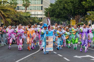 Santa CRUZ DE TENERIFE, İspanya - 13 Şubat 2024: The Coso geçidi, Cavalcada - Avenida de Anaga boyunca, Karnaval 'ın resmi sonu. İnanılmaz sıcak bir akşam, karnaval kostümlü neşeli insanlar eğleniyor..