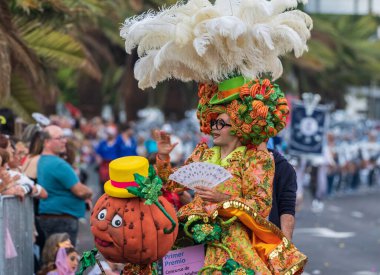 Santa CRUZ DE TENERIFE, İspanya - 13 Şubat 2024: The Coso geçidi, Cavalcada - Avenida de Anaga boyunca, Karnaval 'ın resmi sonu. İnanılmaz sıcak bir akşam, karnaval kostümlü neşeli insanlar eğleniyor..