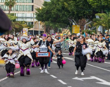 Santa CRUZ DE TENERIFE, İspanya - 13 Şubat 2024: The Coso geçidi, Cavalcada - Avenida de Anaga boyunca, Karnaval 'ın resmi sonu. İnanılmaz sıcak bir akşam, karnaval kostümlü neşeli insanlar eğleniyor..