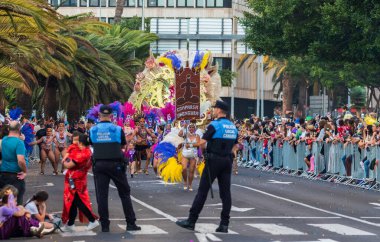 Santa CRUZ DE TENERIFE, İspanya - 13 Şubat 2024: The Coso geçidi, Cavalcada - Avenida de Anaga boyunca, Karnaval 'ın resmi sonu. İnanılmaz sıcak bir akşam, karnaval kostümlü neşeli insanlar eğleniyor..