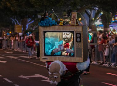 Santa CRUZ DE TENERIFE, İspanya - 13 Şubat 2024: The Coso geçidi, Cavalcada - Avenida de Anaga boyunca, Karnaval 'ın resmi sonu. İnanılmaz sıcak bir akşam, karnaval kostümlü neşeli insanlar eğleniyor..
