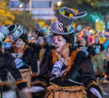 Santa CRUZ DE TENERIFE, İspanya - 13 Şubat 2024: The Coso geçidi, Cavalcada - Avenida de Anaga boyunca, Karnaval 'ın resmi sonu. İnanılmaz sıcak bir akşam, karnaval kostümlü neşeli insanlar eğleniyor..