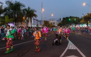 Santa CRUZ DE TENERIFE, İspanya - 13 Şubat 2024: The Coso geçidi, Cavalcada - Avenida de Anaga boyunca, Karnaval 'ın resmi sonu. İnanılmaz sıcak bir akşam, karnaval kostümlü neşeli insanlar eğleniyor..