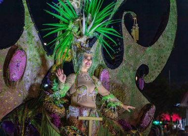 Santa CRUZ DE TENERIFE, İspanya - 13 Şubat 2024: The Coso geçidi, Cavalcada - Avenida de Anaga boyunca, Karnaval 'ın resmi sonu. İnanılmaz sıcak bir akşam, karnaval kostümlü neşeli insanlar eğleniyor..
