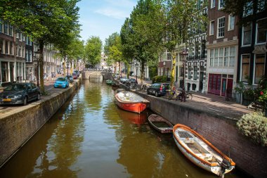 Amsterdam; Hollanda - 7 Temmuz 2018: Bisikletler ve tekneler Amsterdam kanalları etrafında popüler ulaşım şekilleridir.